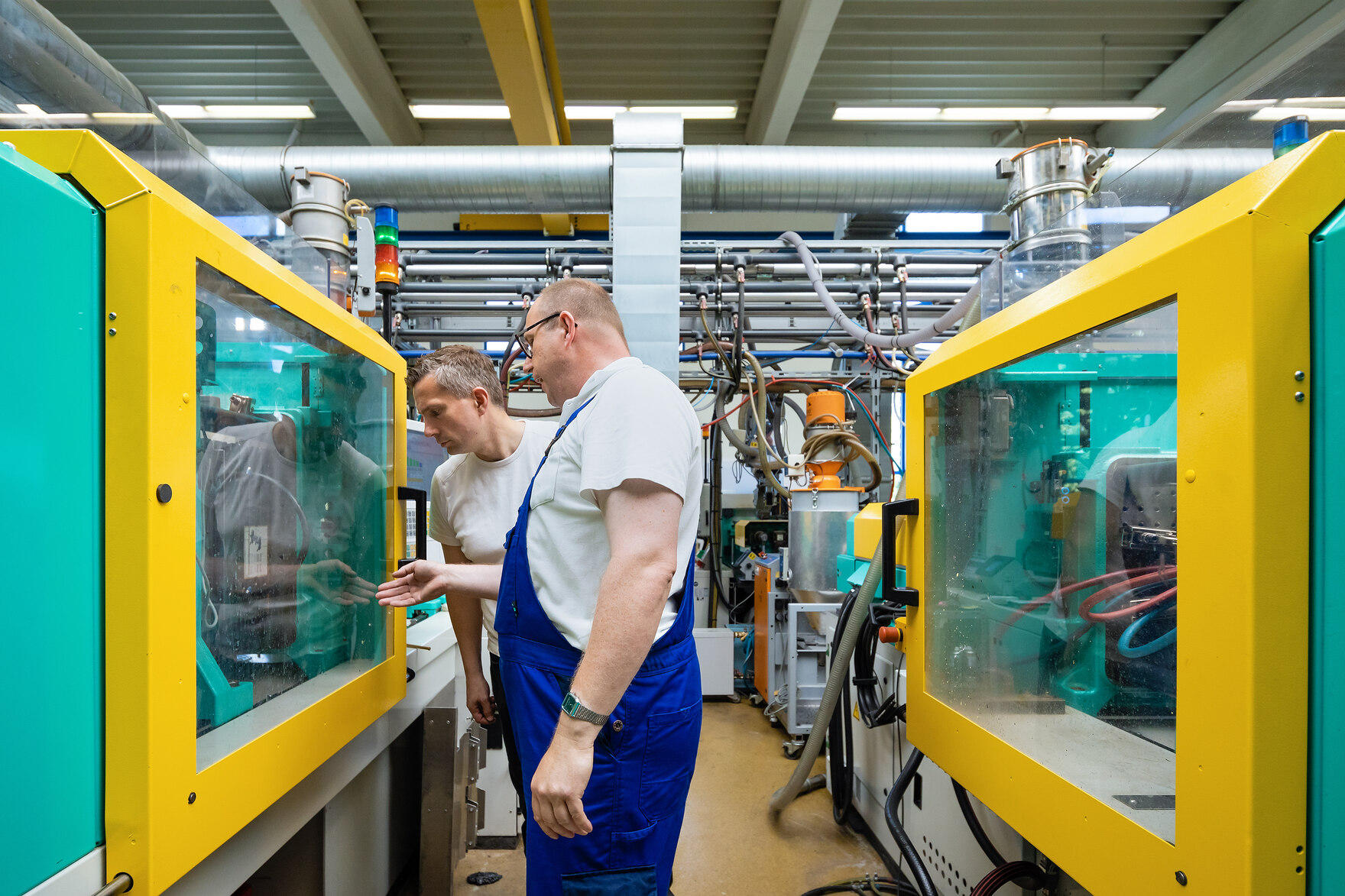 Ein Mitarbeiter bei FEP und Minister Martin Dulig stehen vor der Glasscheibe einer Anlage und schauen in diese hinein.