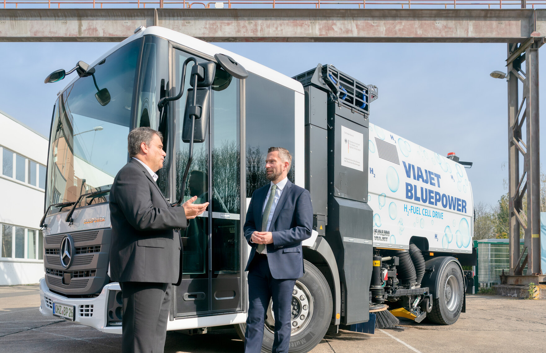 Der Geschäftsführer der FAUN Viatec GmbH, Helmut Schmeh, mit Minister Martin Dulig vor einer Brennstoffzellen-Kehrmaschine.