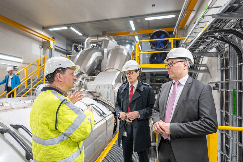 Minster Dirk Panter im Gespräch mit zwei Herren beim Thementag Neue Energien im Innovationskraftwerk Dresden-Reick
