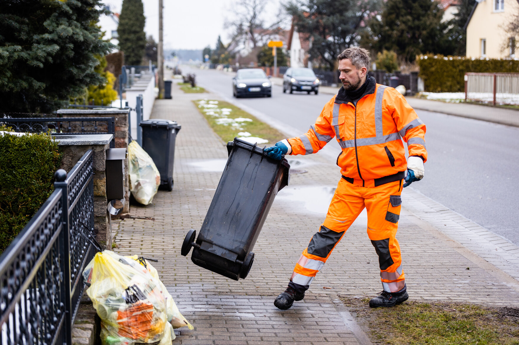 Minister Martin Dulig mit einer Mülltonne in der Hand.