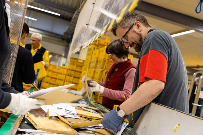 Minister Martin Dulig sortiert Briefe im Briefzentrum der Deutschen Post.